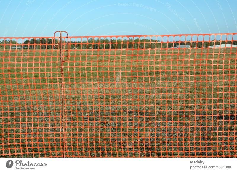 Rotes Netz aus Kunststoff als Zaun zum Schutz der Besucher am Segelflugplatz Oerlinghausen bei Bielefeld im Teutoburger Wald in Ostwestfalen-Lippe Absperrung