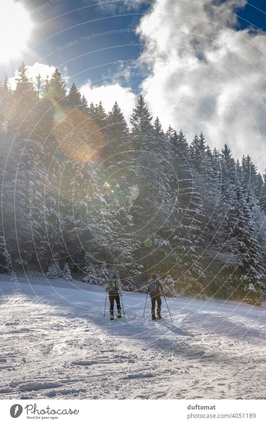 Tourengänger in Winterlandschaft mit Bergen Sport tourengehen Ski Berge u. Gebirge Bergsteiger Schnee beschneit winterlich sportlich draußen zwei lens flair