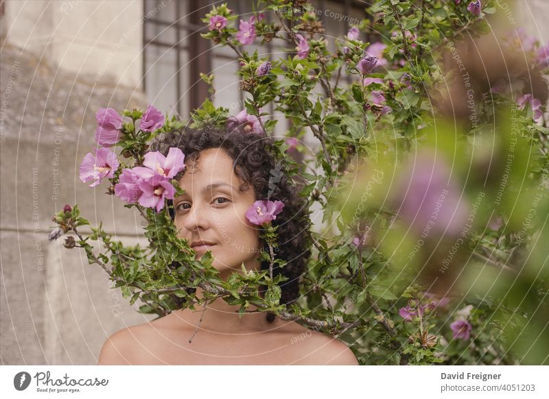 Beauty Headshot einer jungen brünetten Frau mit rosa Blumen im Freien. Gedreht auf analogem 35-mm-Schmalfilm. posierend Model Person schön Schönheit frisch