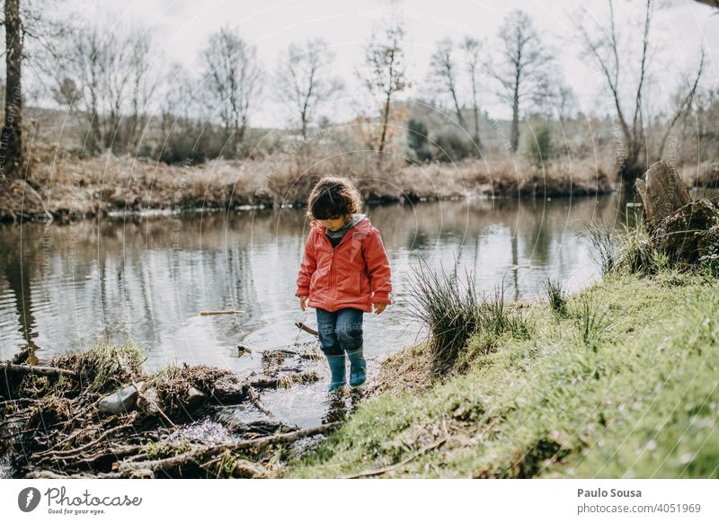Kind geht am Flussufer spazieren Kindheit erkunden Freude Glück Fröhlichkeit Tag Spielen Farbfoto Lifestyle Außenaufnahme Natur reisen Mensch Kaukasier