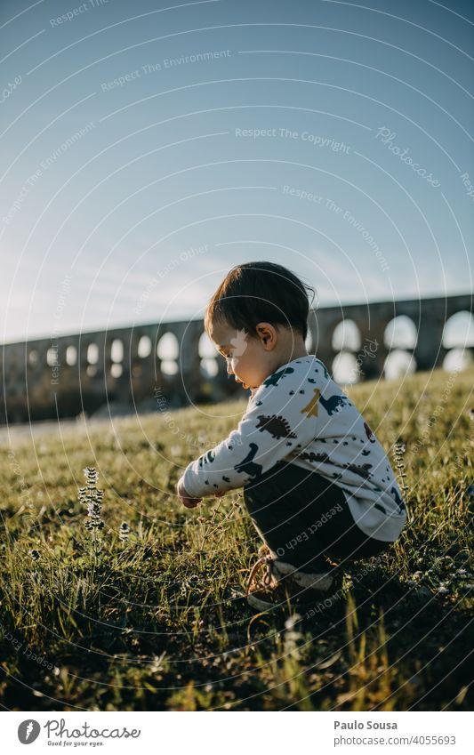 Seitenansicht Kind spielt im Freien Kindheit 1-3 Jahre Kaukasier erkunden authentisch Frühling Frühlingsblume Fröhlichkeit Kleinkind Glück Außenaufnahme Natur