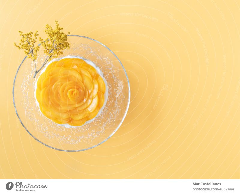 Drei-Milch-Dessert mit Pfirsichen auf gelbem Hintergrund verziert. Platz zum Kopieren. Ansicht von oben. cremig süß frisch Götterspeise Früchte melken
