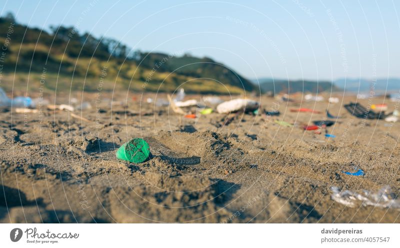 Schmutzige Strandlandschaft voller Müll Kunststoff Sand dreckig kontaminiert Umwelt Natur Verschmutzung Abfall Küste Kunststoffdeckel Problematik