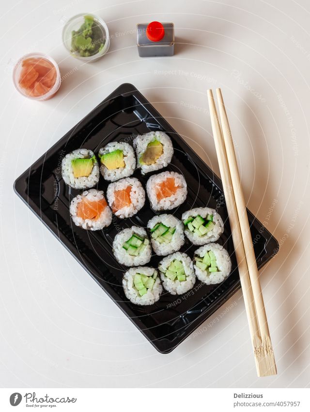 Ansicht von oben auf frisches Sushi zum Mitnehmen auf weißem Hintergrund mit Kopierbereich sushis Stäbchen Lebensmittel Ingwer Wasabi Japanisch