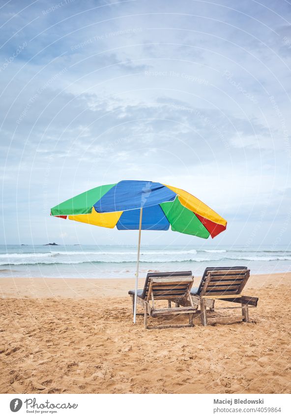 Sonnenschirm mit zwei Sonnenliegen an einem leeren tropischen Strand, Sri Lanka. Urlaub Regenschirm Flucht sich[Akk] entspannen friedlich Stuhl Liege Sonnenbank