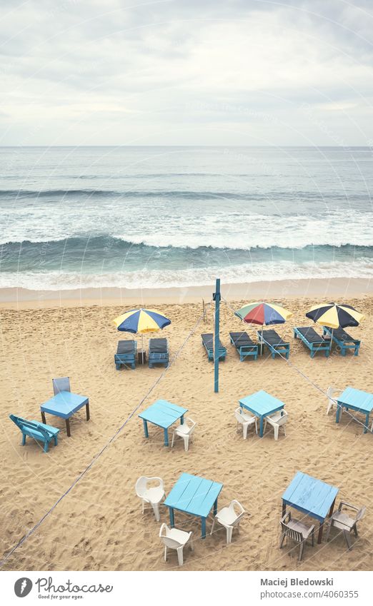 Luftaufnahme eines leeren tropischen Strandes mit Sonnenschirmen, Sonnenliegen, Tischen und Stühlen, Farbabtönung aufgetragen, Sri Lanka. Antenne Resort Urlaub