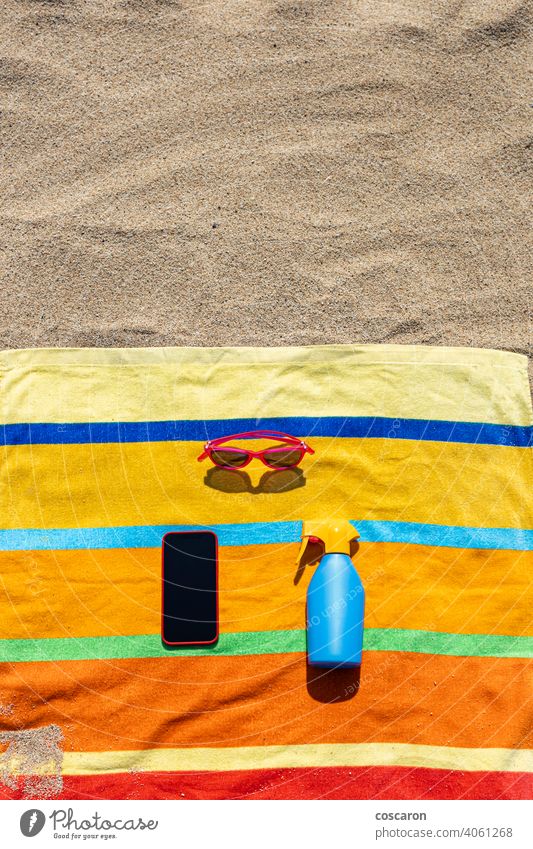 Handtuch, sunsreen, Sonnenbrille und Smartphone am Strand. Konzept für den Sommer. blau Flasche Zelle farbenfroh Mitteilung Mitteilungen Kopie Textfreiraum