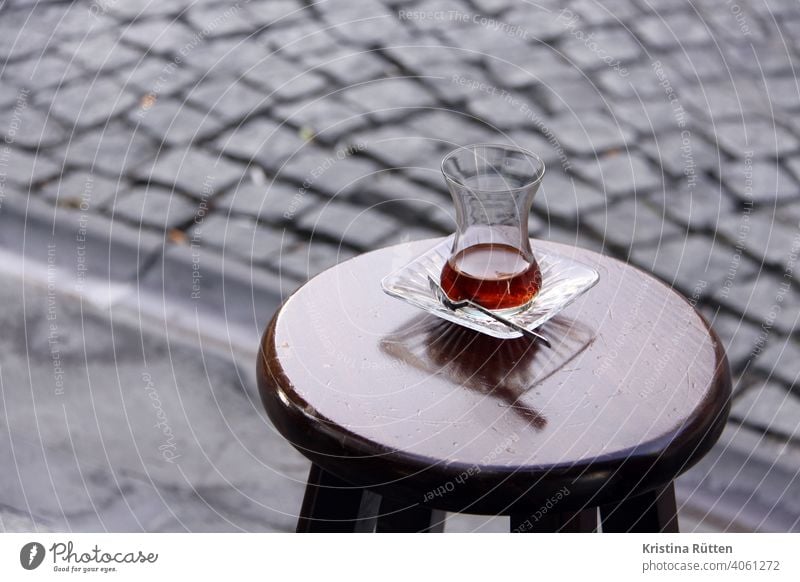 ein glas tee steht auf einem hocker am straßenrand Çay teeglas barhocker draußen gehweg teepause türkisch türkischer tee traditionell schwarz schwarzer tee