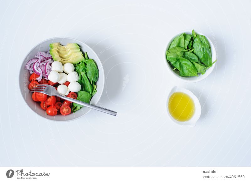 Frühstücks-Gesundheitsdiät-Bowl mit Kirschtomaten, Avocado, Blattspinat, Mozzarella und roten Zwiebeln mit Olivenöl-Dressing Tomate Gemüse Salatbeilage