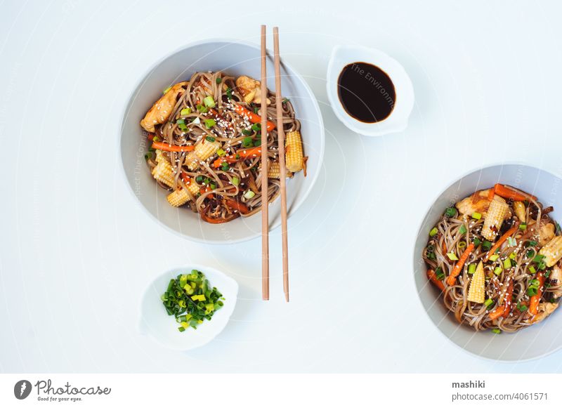 Japanisches Gericht Buchweizen-Soba-Nudeln mit Huhn und Gemüse Karotte, Zwiebel und Babymais soba Lebensmittel Essstäbchen Schalen & Schüsseln Mahlzeit