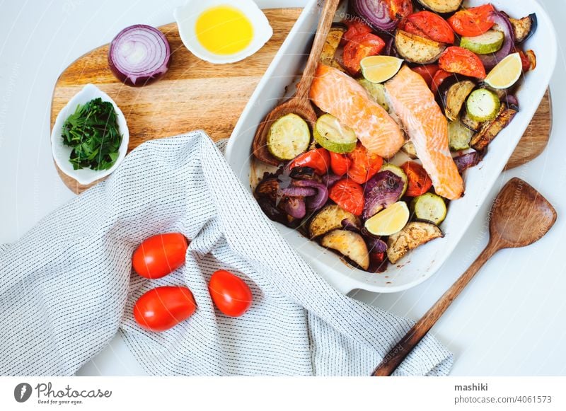 Ofengeröstete Gemüsemischung - Tomate, rote Zwiebel, Zucchini und Aubergine mit gebackenem Lachs. Gesunde Diät vegetarisches Abendessen oder Mittagessen