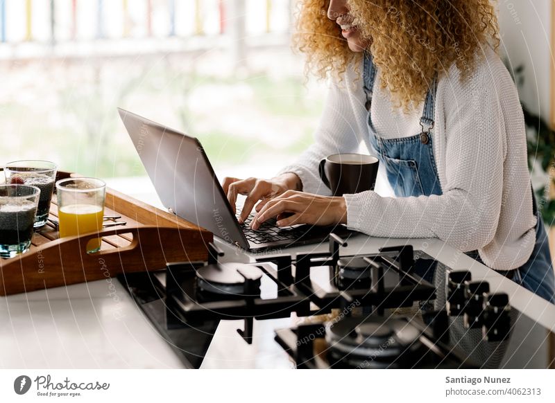Unerkennbare Frau benutzt Laptop in der Küche. Lebensmitte Paar Liebe Essen zubereiten heimwärts gemütlich Kaukasier Partnerschaft vorbereitend Glück Person