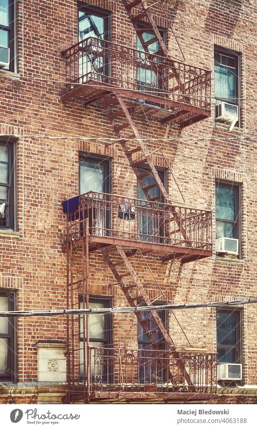 Altes Backsteinhaus Gebäude mit Eisen Feuerleiter, Farbe getönten Bild, New York City, USA. New York State Großstadt Feuertreppe Mietshaus Haus nyc Manhattan