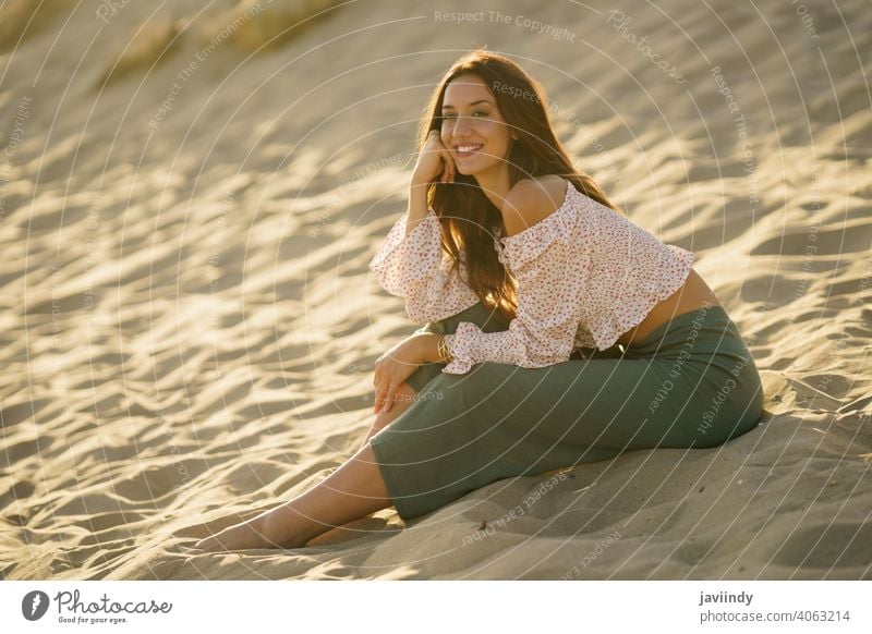 Lächelnde Frau sitzt auf dem Sand des Strandes Sitzen Erwachsener Person Urlaub Kaukasier Dame Mädchen Feiertag sich[Akk] entspannen außerhalb jung reisen
