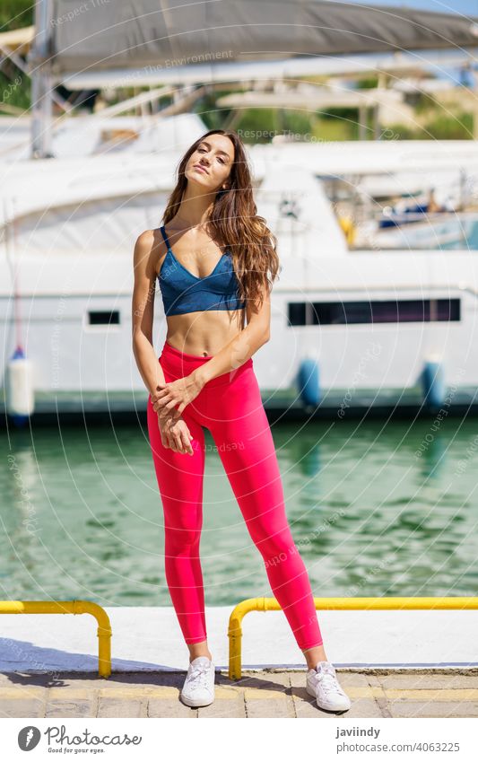 Fitness-Model in rotem Sportswear-Outfit posiert am Hafen. Frau Mädchen passen Aktivität Training jung Shorts Freizeit Jogger Kaukasier Sportbekleidung Legging
