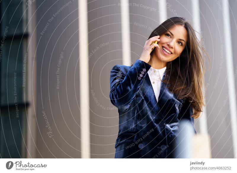 Business-Frau im blauen Anzug mit Smartphone in einem Bürogebäude. Geschäftsfrau Mädchen klug Telefon Person Gerät Lifestyle urban Hintergrund Dame elegant