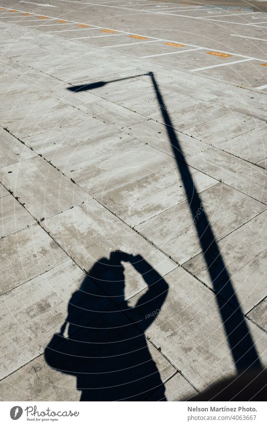 Silhouette eines Mannes, der ein Foto mit einer anderen Silhouette einer Stange macht schwarz auf weiß Fotografie künstlerisch kreativ Linien Zahlen Sonnenlicht
