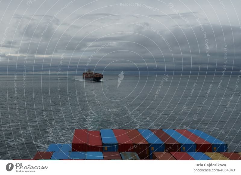 Blick auf ein Containerschiff von einem anderen Schiff aus, das sich dem Hafen von Vancouver, Kanada, vom Pazifischen Ozean im Bereich der Salish Sea nähert.