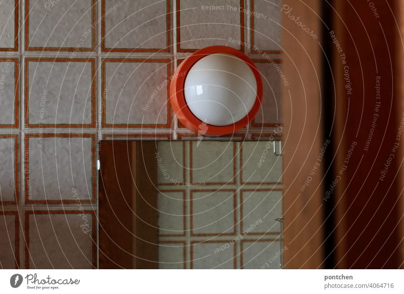 Blick in ein Badezimmer aus den 70ern. retro. toilette, fließen, orange badezimmer tür seventies Häusliches Leben 70er Jahre Design lampe Vergangenheit