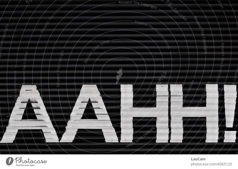 Weißer Schriftzug „AAHH!“ auf einem schwarzen Hintergrund weiß schwarzweiß Schriftzeichen Buchstaben Wort Lautmalerei lautmalerisch Typographie Text
