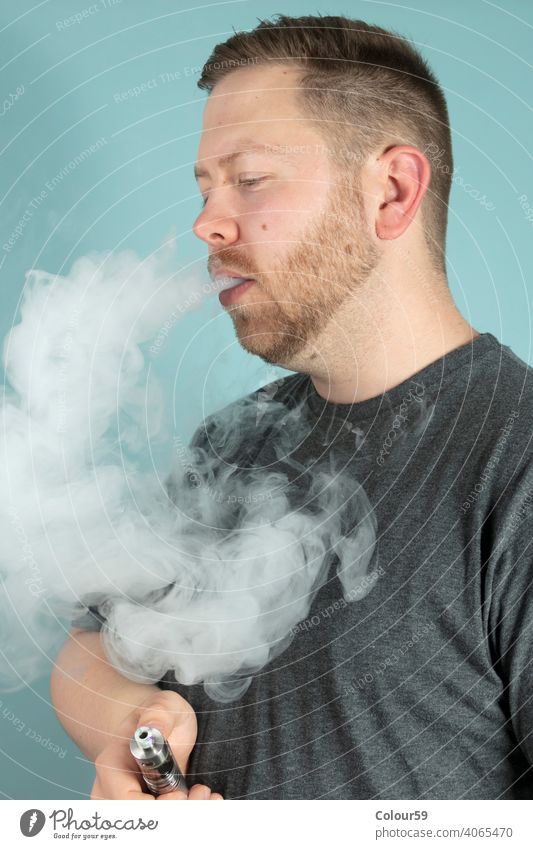 Junger Mann, der eine E-Zigarette raucht süchtig machend Cloud elektronisch ausatmend Nikotin Rauch Raucherin Rauchen Stimulans ungesund Raps Verdampfer Laster