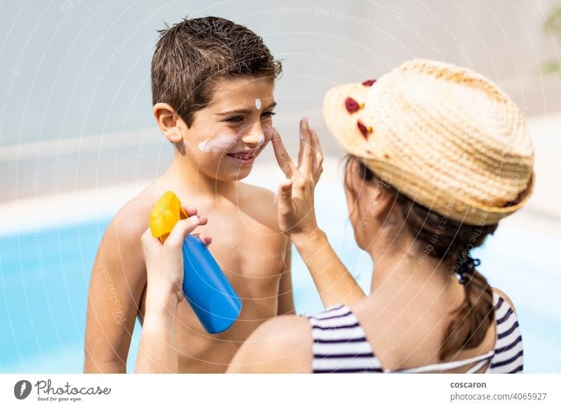Mutter, die ihrem Sohn an einem Sommertag Sonnenschutzmittel aufträgt bewerben anwendend Strand Junge Pflege Kind Kindheit Kosmetik Sahne Gesicht Familie Glück