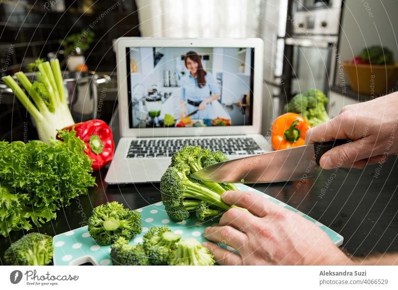 Schöne glückliche Frau Streaming Broadcast-Video-Blog über leckere und gesunde Lebensmittel aus der Küche zu Hause. Gesunder Lebensstil und soziale Medien. Mann beobachten Video Rezept auf Laptop und Kochen zu Hause.