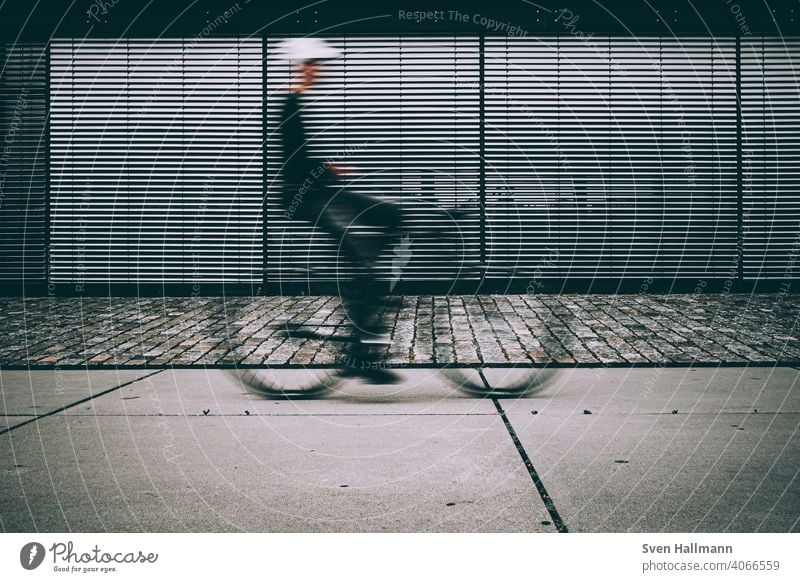 Verschwommener Radfahrer  vor geschlossener Jalousie Fahrrad Minimalismus Silhouette abstrakt bremerisch Langzeitbelichtung linien urban Radfahren Biker