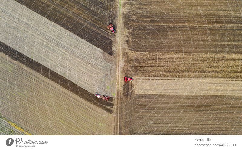 Oben Draufsicht Schuss von drei Traktoren, sie ziehen Maschinen, über Ackerfeld, Vorbereitung Boden für neue Ernte oben Antenne landwirtschaftlich Ackerbau
