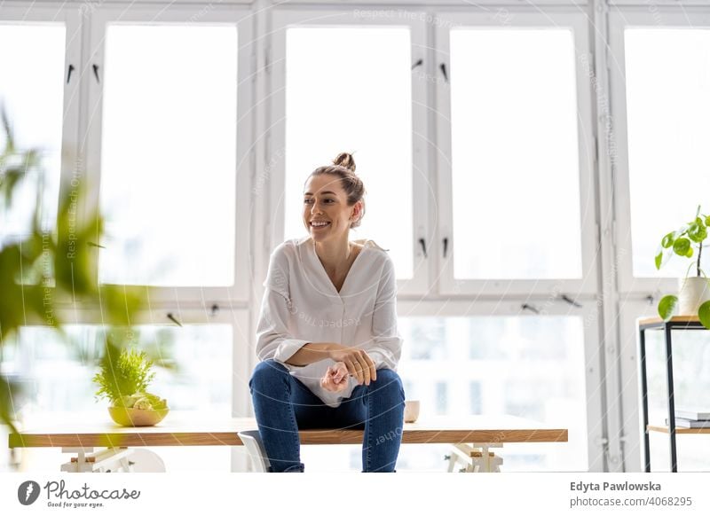 Porträt einer lächelnden kreativen Frau in einem modernen Loft-Raum Jahrtausende Schüler Hipster im Innenbereich Fenster natürlich Mädchen Erwachsener attraktiv