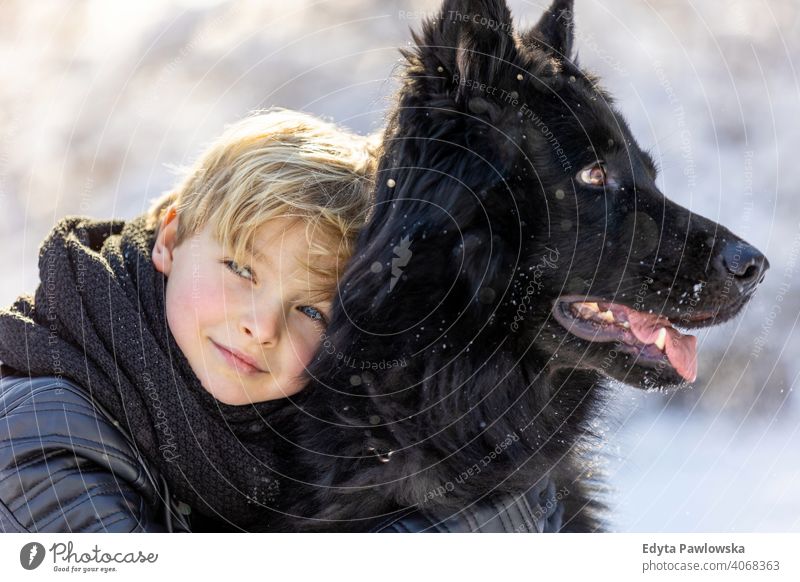 Kleiner Junge genießt den Winter mit seinem Hund schwarz Russisch Aktivität aktiv Abenteuer Tag männlich Begleiter Pflege im Freien Wald Schönheit Frost Natur