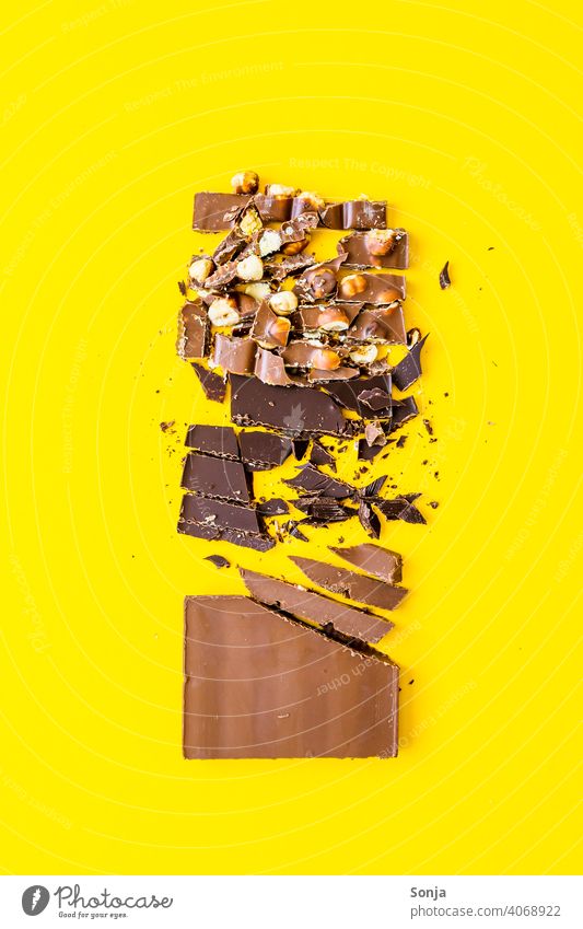 Variation von Schokolade Stücken auf einem gelben Hintergrund variation Nuss Süßwaren Studioaufnahme Stil Ernährung Farbfoto Zucker braun Foodfotografie