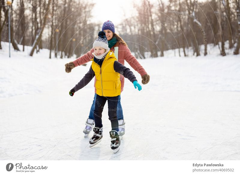 Mutter und Sohn beim Schlittschuhlaufen auf gefrorenem Teich Tochter Saison Zusammensein heiter Spaß Kind Menschen Park Feiertag Wald Kindheit Frau Mädchen