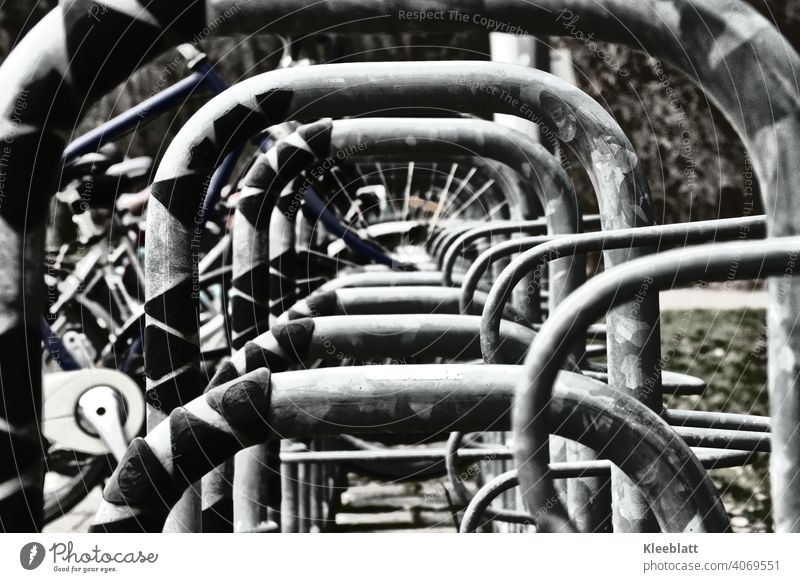 Schwarz-Weiß-Aufnahme  Zentraler Blick durch einen Fahrradständer Rad parken schwarz weiß schwarz-weiß Metall Speichen Fahrradfahren Detailaufnahme Straße