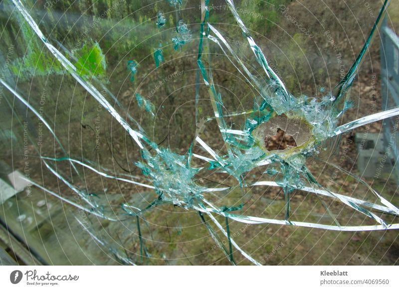 Zerbrochene Panzerglasscheibe einer Fußgängerbrücke - Detailaufnahme Zerbrochenes Fenster panzerglas Loch Splitter Glas kaputt Zerstörung Farbfoto Außenaufnahme