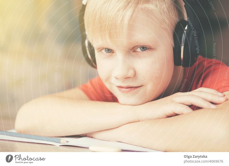 Blondy Teenager-Junge in Kopfhörer ruht und Musik hören . Lächeln Kind im Innenbereich niedlich grau Auge Hausaufgabe Spaß Kaukasier blond Hand Bleistift
