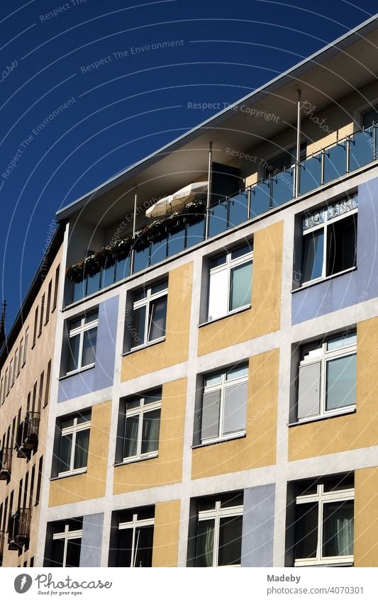 Restaurierte zweifarbige Fassade in Beige und Blau mit überdachtem Balkon im Sommer bei Sonnenschein in der Innenstadt von Frankfurt am Main in Hessen Wohnhaus
