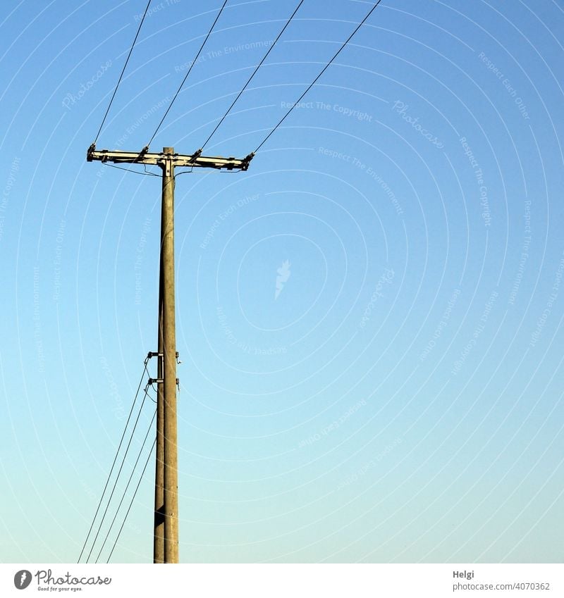 Strommast aus Holz mit Stromleitungen alt Kabel Elektrizität Leitung Energiewirtschaft stromleitung Stromtransport Außenaufnahme CO2 Himmel blauer Himmel