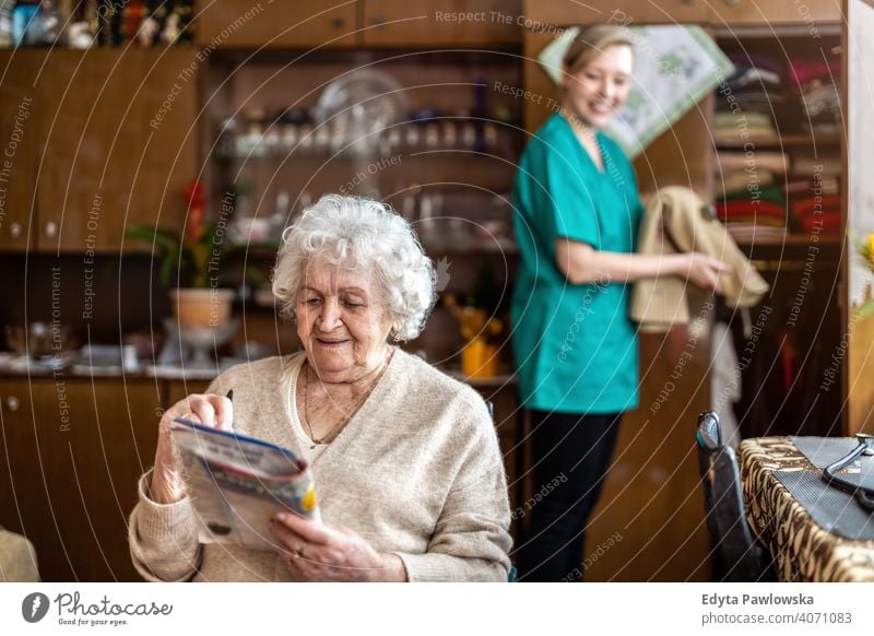 Weibliche Krankenschwester kümmert sich um eine ältere Frau zu Hause echte Menschen offen Senior reif Kaukasier heimwärts alt Alterung häusliches Leben