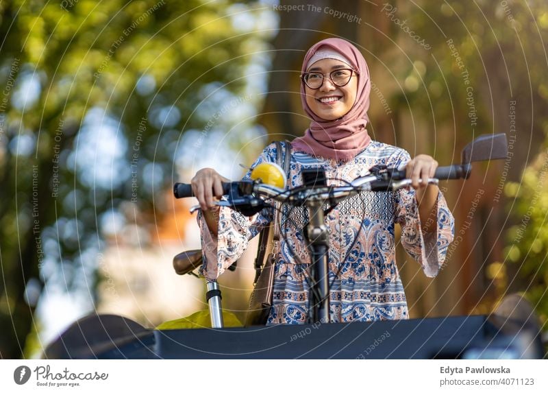 Selbstbewusste muslimische Frau mit Lastenfahrrad im städtischen Bereich Hijab Kopftuch Islam arabisch Sommer Mädchen Menschen junger Erwachsener Lifestyle