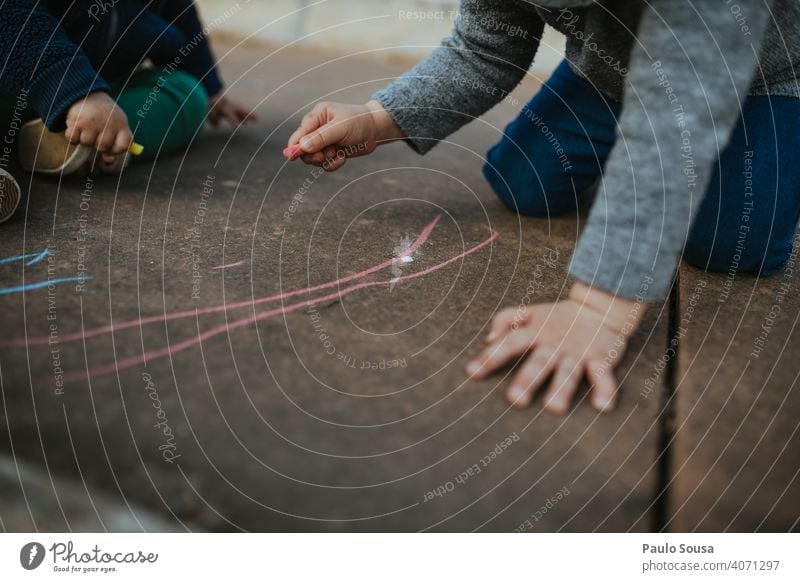Kind zeichnet mit farbiger Kreide auf dem Boden Kreidezeichnung Kreativität Zeichnung Kindheit Straße Spielen Freude Kinderspiel Kunst Freizeit & Hobby