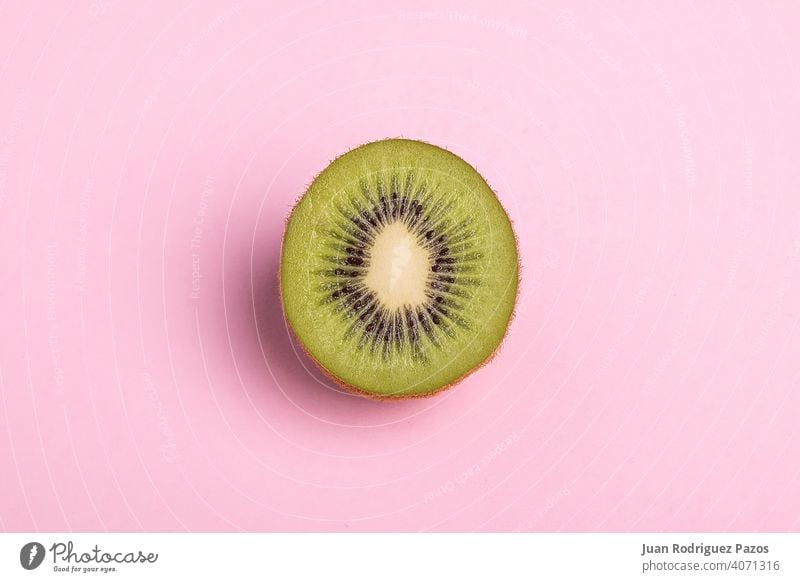 Nahaufnahme einer aufgeschnittenen Kiwi auf pastellrosa Hintergrund. Frucht sehr wenige vereinzelt Scheibe niemand Konzept Gesundheit Vegetarier süß