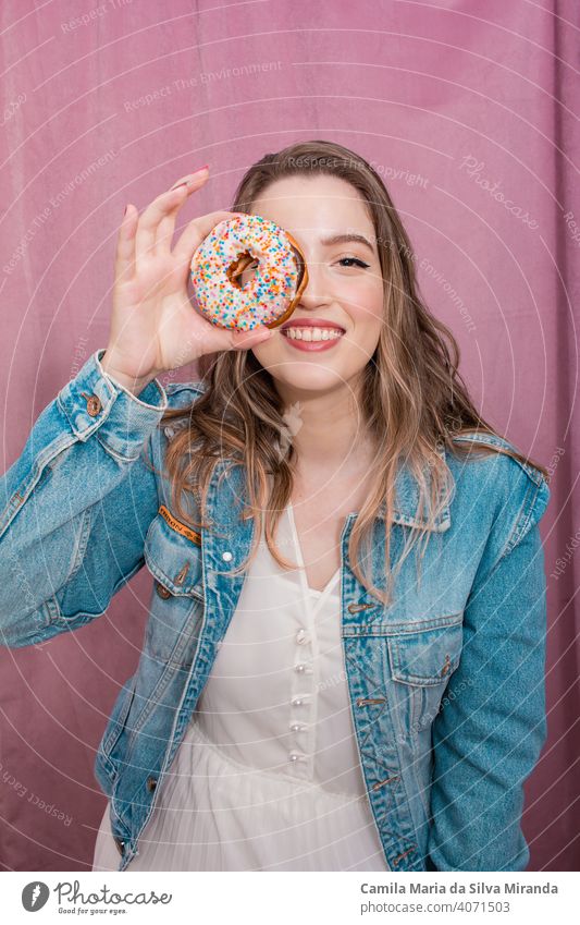 Schöne Frau hält einen Donut. attraktiv Hintergrund Bäckerei schön Schönheit heiter farbenfroh Konditorei niedlich lecker Dessert Krapfen Donuts Doughnut Ostern