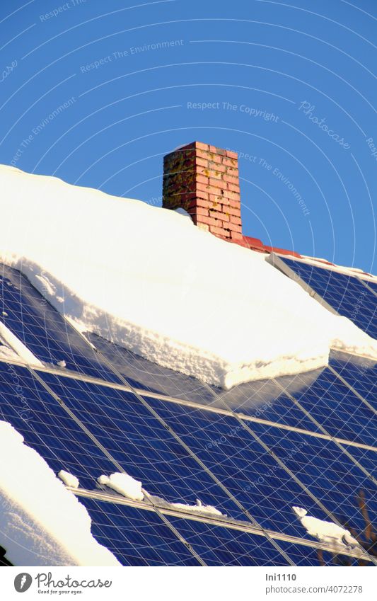 Photovoltaikanlage auf der Dachfläche eines Wohnhauses teilweise mit Schnee bedeckt Solarenergie Stromversorgung Energie Sonnenenergie CO2 Umweltfreundlich