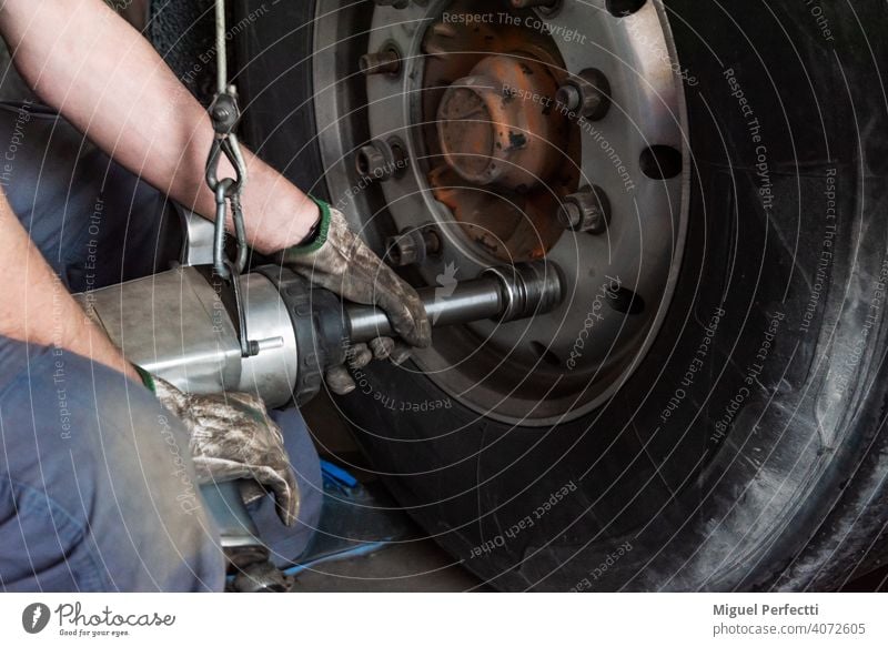 Bediener einer Reifenwerkstatt, der eine Maschine zur Montage oder Demontage eines Lkw-Rads verwendet. Mechaniker Werkzeug Lastwagen Reparatur fixieren Dienst