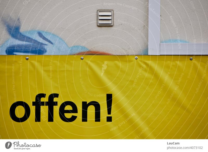 Schwarzer Schriftzug "offen!" auf einer gelben Plastikplane mit Graffiti Buchstaben Wand schwarz gelbschwarz gelb-schwarz Hauswand Fassade Wort Schriftzeichen