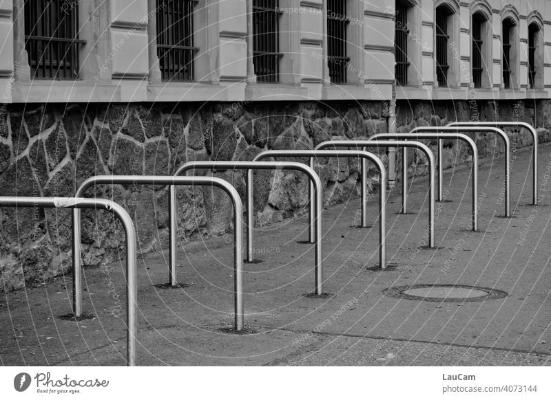 Leere metallene Fahrradständer vor einer Schule in der Corona-Pandemie Fahrradfahren Rad Symmetrie symmetrisch Radständer abstrakt leer Mobilität Leerstand