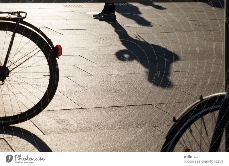 Warten zwischen Rädern warten Mensch Schatten stehen Fahrrad Platz Fußgängerzone urban Schattenspiel allein einzeln