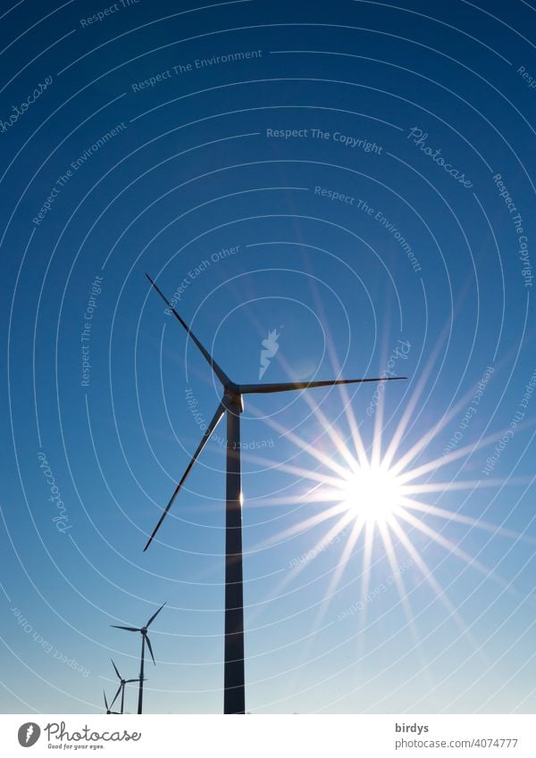 Windkraftanlage. Windräder zur Stromerzeugung vor blauem Himmel mit strahlender Sonne Windenergie Wolkenloser Himmel Sonnenstrahlen Erneuerbare Energie Windrad