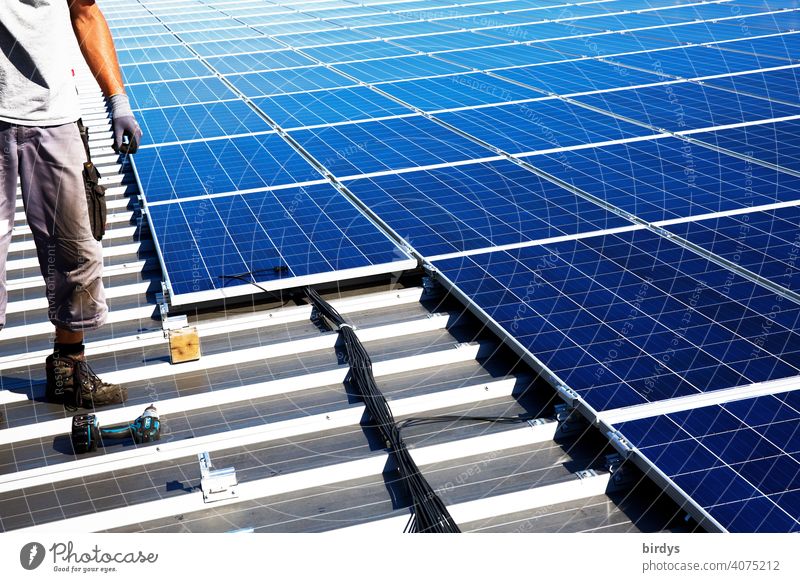 Montage einer Photovoltaikanlage auf einem Fabrikdach, PV-Anlage, Solartechnik Dachmontage Sonnenenergie Solarenergie Energiewirtschaft nachhaltig